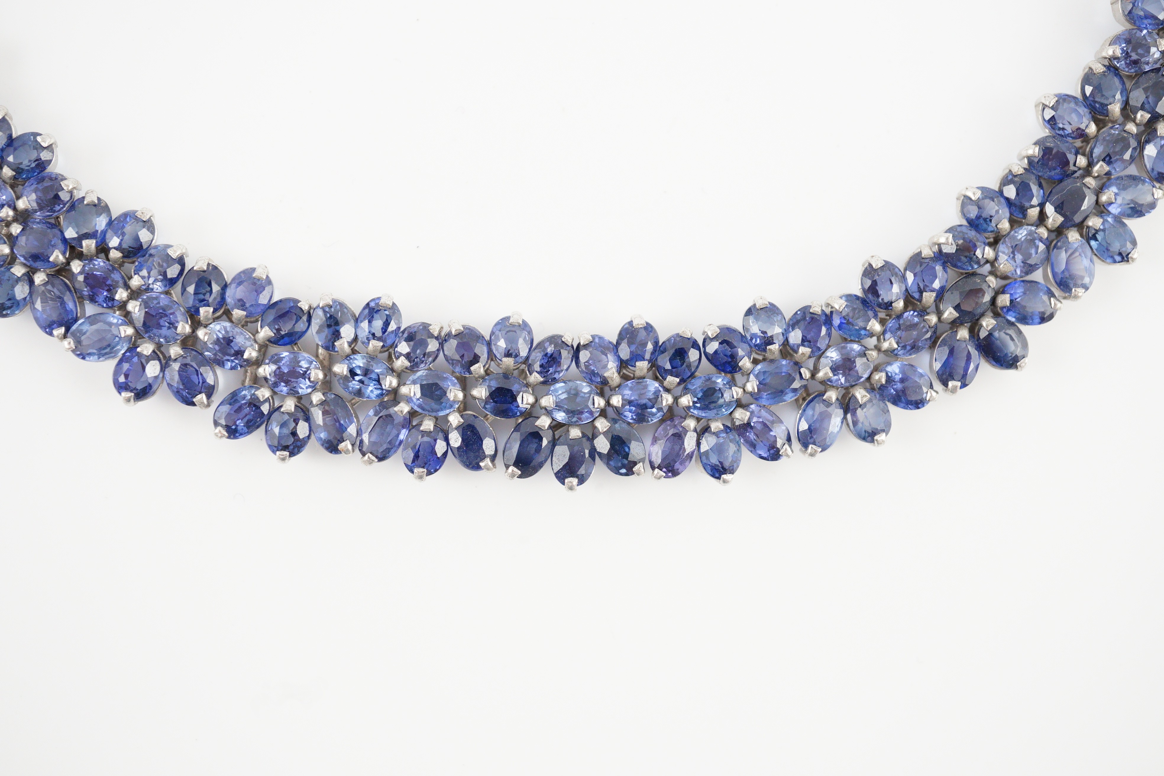 An 18K white gold and synthetic sapphire? flower head cluster set necklace